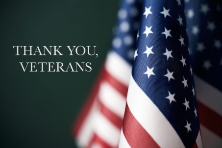 american flags and the text thank you veterans against a dark green background